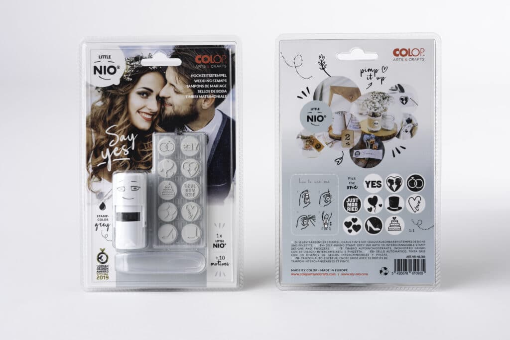 Die Verpackung des Stempelsets „Say Yes“ von Little Nio zeigt ein lächelndes Paar, perfekt für alle, die gerade mit der Hochzeitsplanung beschäftigt sind. Auf der Vorderseite sind die Stempel abgebildet, während auf der Rückseite bezaubernde Designs wie Herzen und Ringe zu sehen sind, ideal, um jedem Hochzeitsanlass einen Hauch Liebe zu verleihen.