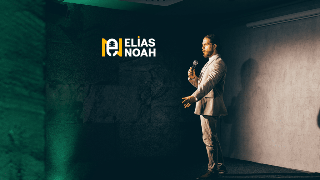 Eine Person im Anzug steht mit einem Mikrofon auf der Bühne und hält eine Rede über Hochzeitsplanung. Im Hintergrund ist der Text „ELÍAS NOAH“ mit einem Mikrofon-Logo zu sehen, umgeben von einer Atmosphäre, die an eine elegante Hochzeit erinnert. Die Beleuchtung verleiht der Szene einen warmen Ton.