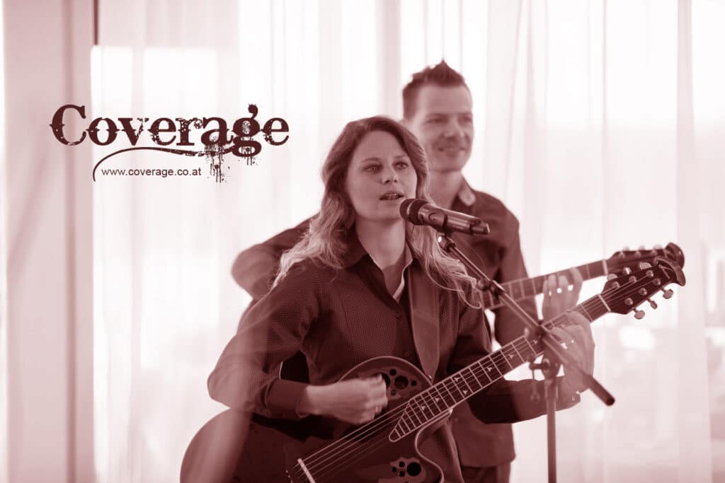 Eine Frau singt leidenschaftlich in ein Mikrofon und spielt dabei eine Akustikgitarre. Im Hintergrund klimpert ein Mann auf einer anderen Gitarre. Das Wort „Coverage“ und die URL einer Website werden in der oberen linken Ecke angezeigt. Dies erzeugt einen Sepia-Ton im Vintage-Stil, der perfekt ist, um unvergessliche Hochzeitsmomente festzuhalten.