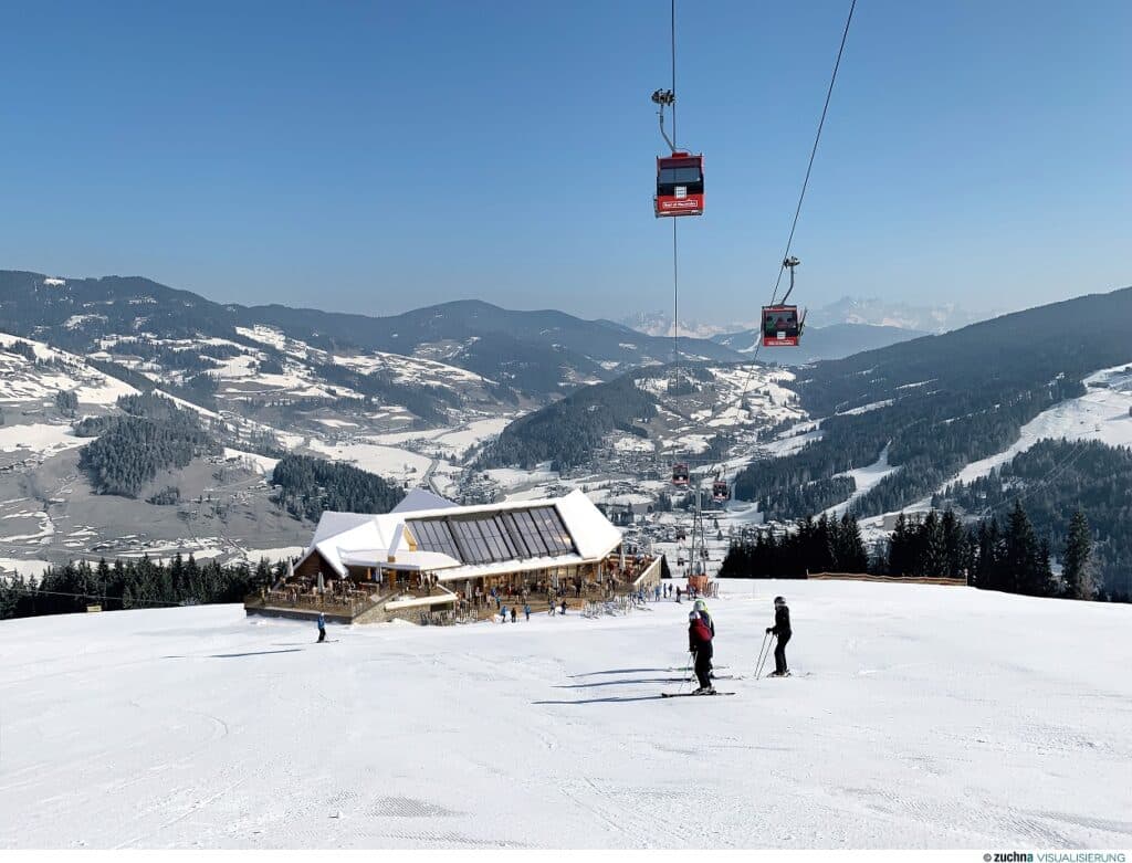 Eine verschneite Berglandschaft mit einer Skihütte, perfekt für die Hochzeitsplanung, ist von schneebedeckten Bäumen umgeben. Mehrere Skifahrer gleiten den Hang hinunter, während rote Gondeln über ein Kabel darüber gleiten. Der Himmel ist klar und blau und gibt den Blick auf schneebedeckte Gipfel in der Ferne frei – ideal für eine Traumhochzeit.