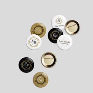 Verschiedene runde Buttons auf grauem Hintergrund mit Initialen und Textdesigns zum Thema Hochzeit in den Farben Schwarz, Gold und Weiß. Einige Buttons zeigen Initialen, während andere den Namen „Lisa Brooks“ und den Satz „Schwester der Braut“ tragen, perfekt für alle, die sich intensiv mit der Hochzeitsplanung beschäftigen.