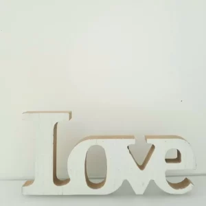 Ein Holzblock mit dem Wort „Liebe“ steht vor einem schlichten weißen Hintergrund und verleiht jedem Hochzeitsdekor einen Hauch von Eleganz. Die Buchstaben im Serifenstil sind weiß lackiert und haben eine subtile Holzstruktur, die Hochzeitsplanungsthemen wunderbar ergänzt.