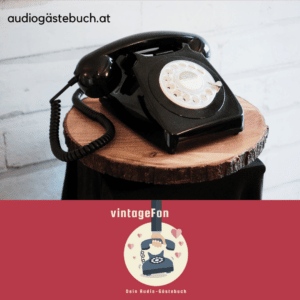 Ein schwarzes Vintage-Wählscheibentelefon steht auf einem kleinen Holzhocker vor einer weißen Backsteinwand und verleiht jeder Hochzeitsdekoration Charme. Darunter erscheinen der Text „audiogästebuch.at“ und „vintageFon“ mit einer Telefongrafik, perfekt für eine einzigartige Hochzeitsplanung.