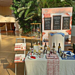 Für die Hochzeitsplanung wird eine Hochzeitsweinausstellung mit Flaschen, Broschüren und Dekorationsartikeln aufgebaut. Eine Tafel informiert über Verkostungen und Preise in dem geräumigen, mit Pflanzen gefüllten Veranstaltungsort.