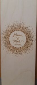 Eine Holzbox mit eingraviertem Kreismuster, perfekt für Hochzeitserinnerungen. Im Kreis steht „Melanie & Maik“ mit dem Datum „31.07.2021“ darunter, umgeben von einem gepunkteten Muster. Ideal für alle, die gerade mitten in der Hochzeitsplanung stecken oder von ihrem besonderen Tag träumen.